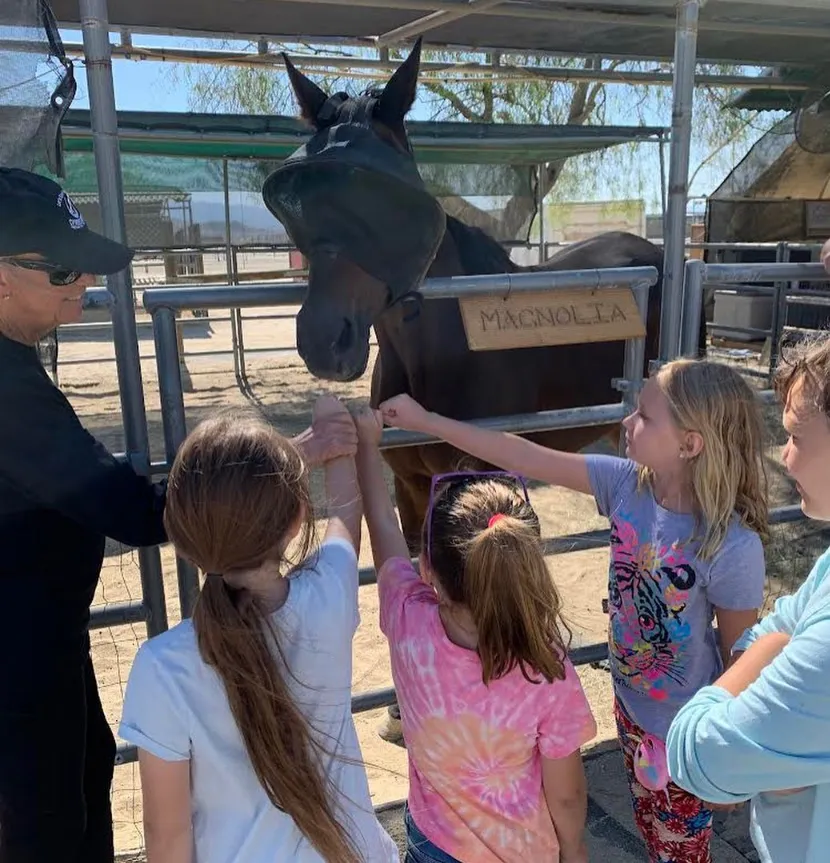 Children petting a rescue horse at the ranch